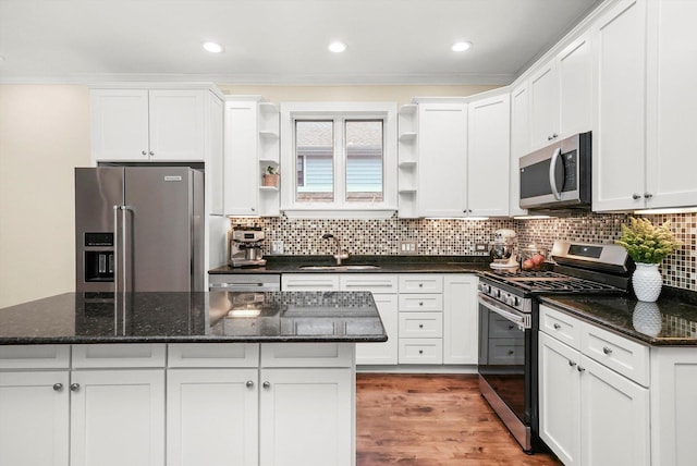 kitchen with dark stone counters, sink, white cabinets, and stainless steel appliances