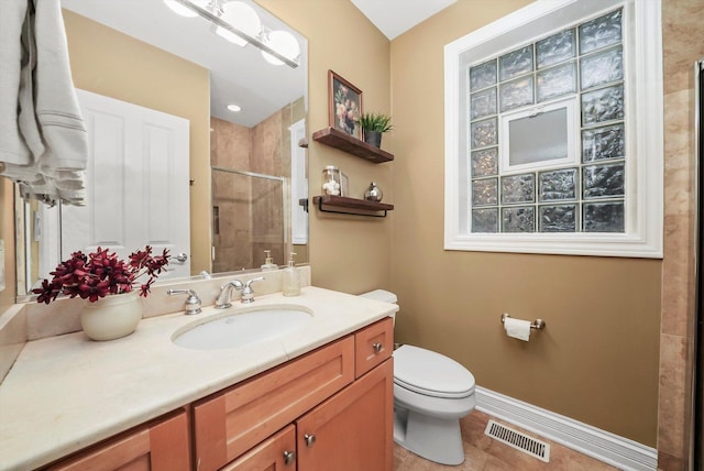 bathroom featuring tile patterned floors, toilet, vanity, and walk in shower