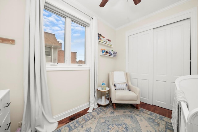 sitting room featuring ceiling fan, wood-type flooring, and crown molding