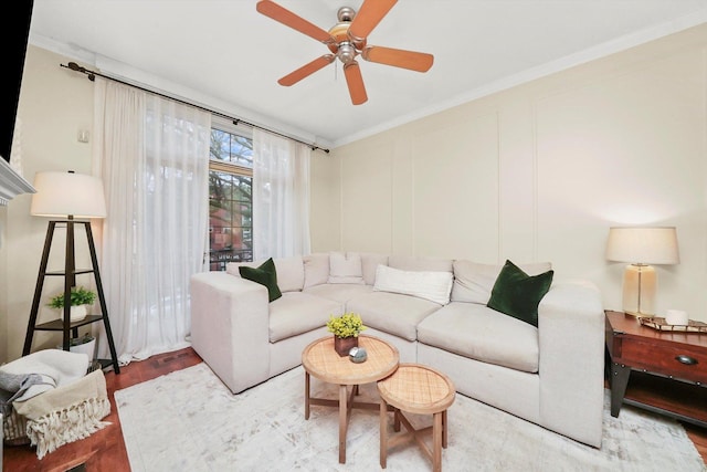 living room with crown molding, ceiling fan, and hardwood / wood-style flooring