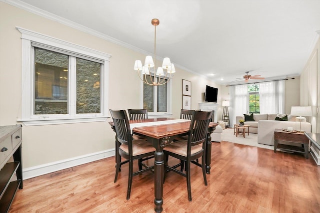 dining room with crown molding, ceiling fan with notable chandelier, and light wood-type flooring