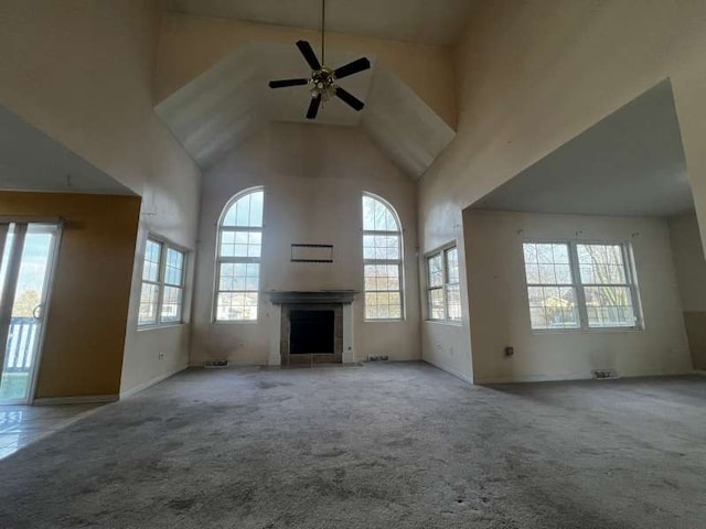 unfurnished living room featuring ceiling fan, light colored carpet, and high vaulted ceiling