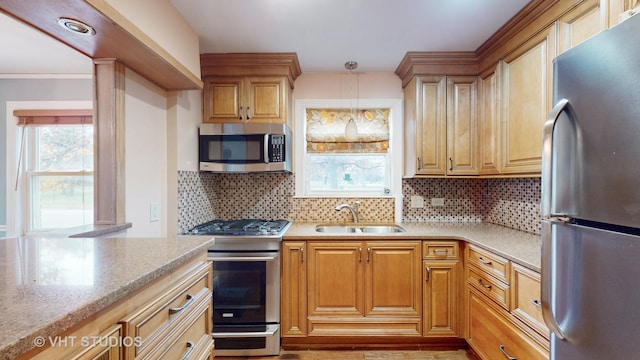 kitchen with appliances with stainless steel finishes, backsplash, hanging light fixtures, and sink