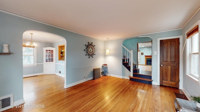 spare room featuring hardwood / wood-style flooring, an inviting chandelier, and ornamental molding