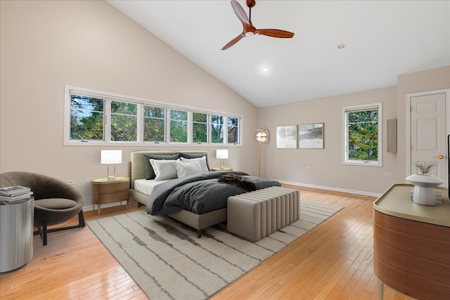 bedroom featuring multiple windows, light hardwood / wood-style floors, high vaulted ceiling, and ceiling fan