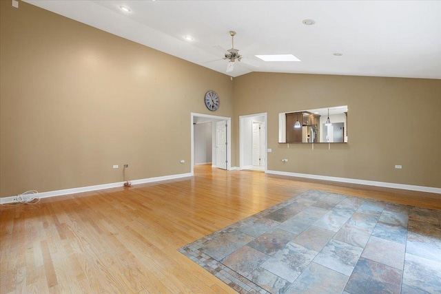 unfurnished living room featuring ceiling fan, light hardwood / wood-style floors, and lofted ceiling with skylight