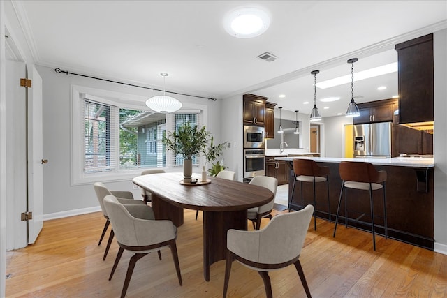 dining space featuring light hardwood / wood-style flooring and ornamental molding