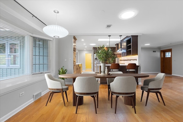 dining room featuring light hardwood / wood-style floors and ornamental molding