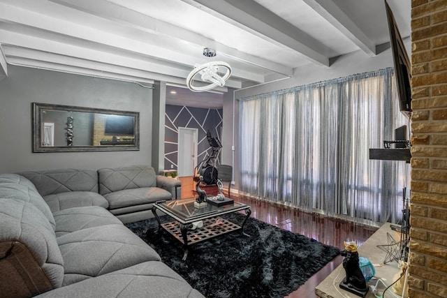 living room with beam ceiling, hardwood / wood-style floors, and an inviting chandelier