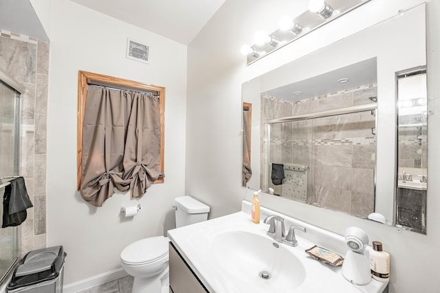 bathroom with tile patterned floors, vanity, toilet, and a shower with door