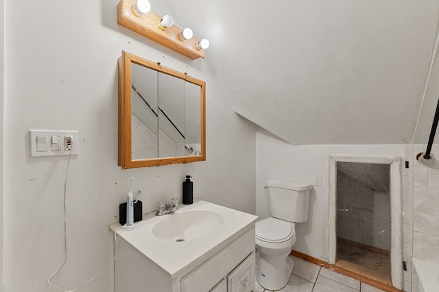 bathroom featuring tile patterned flooring, vanity, lofted ceiling, and toilet