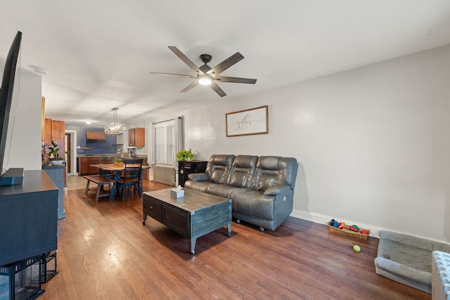 living room with ceiling fan and dark wood-type flooring