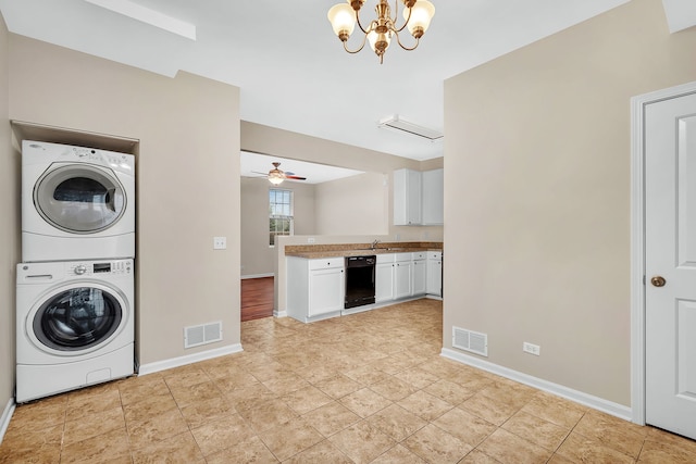 laundry area featuring ceiling fan with notable chandelier and stacked washing maching and dryer