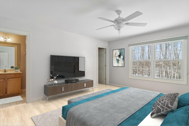 bedroom with ceiling fan, sink, and connected bathroom