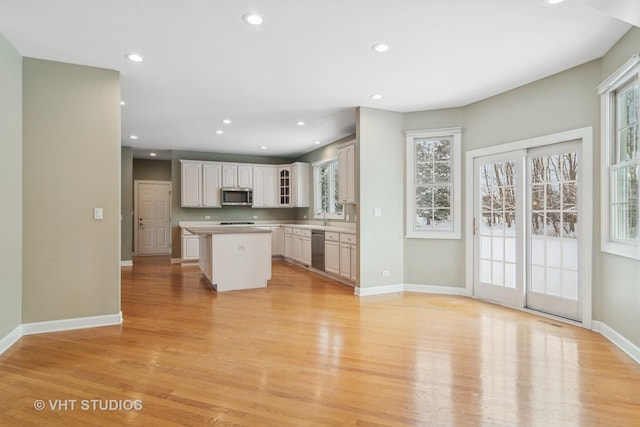 kitchen with plenty of natural light, a kitchen island, stainless steel appliances, and light hardwood / wood-style flooring