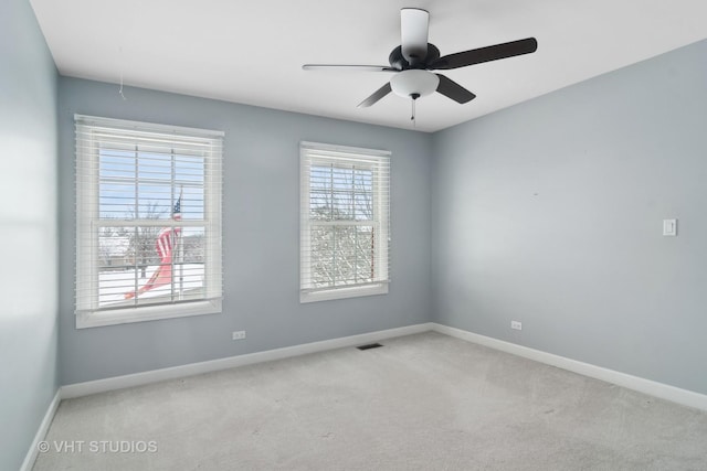 spare room with ceiling fan and light carpet