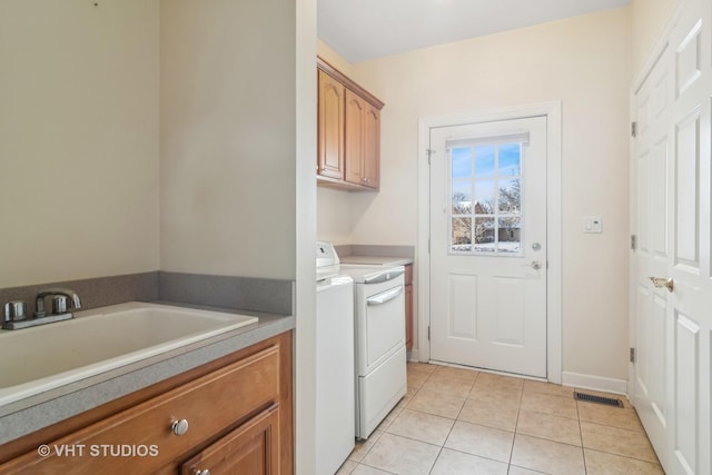 laundry room featuring cabinets, light tile patterned floors, separate washer and dryer, and sink