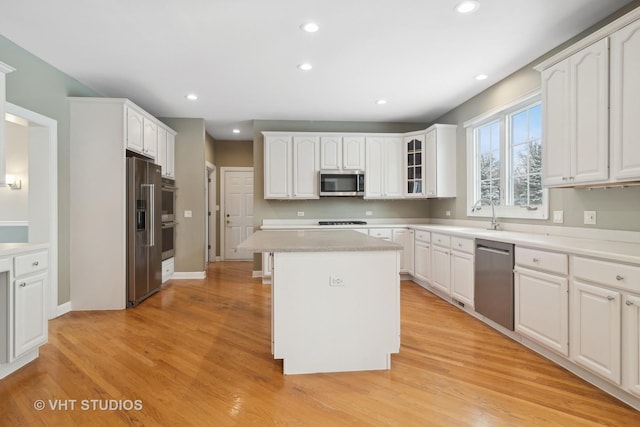 kitchen featuring light hardwood / wood-style floors, a center island, white cabinetry, and stainless steel appliances