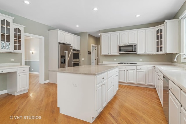 kitchen featuring white cabinets, appliances with stainless steel finishes, a kitchen island, and sink