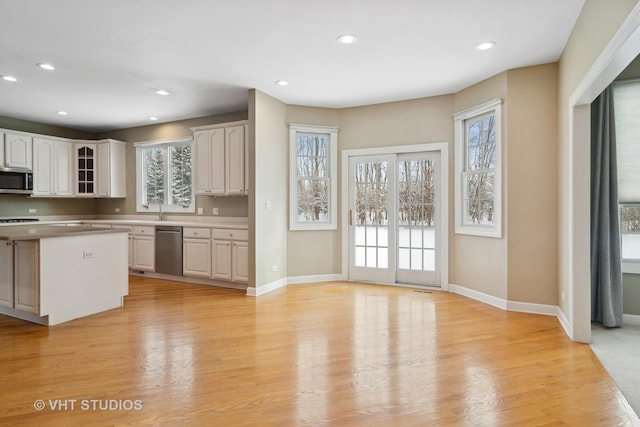 kitchen with light wood-type flooring, white cabinetry, and sink