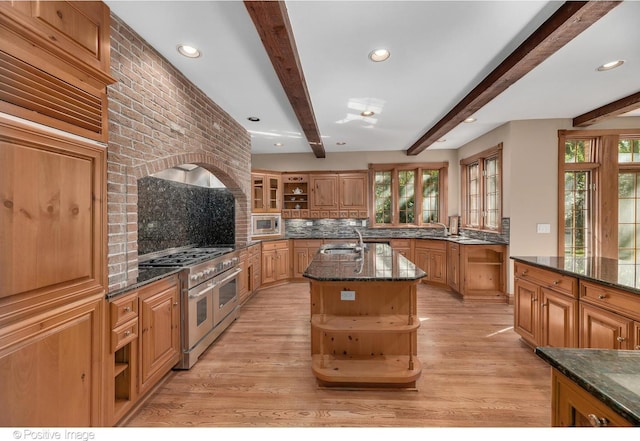 kitchen featuring sink, an island with sink, plenty of natural light, and appliances with stainless steel finishes