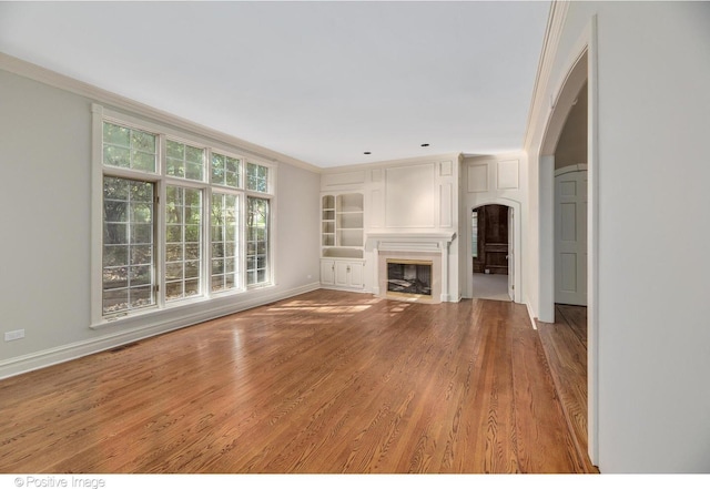 unfurnished living room featuring crown molding and hardwood / wood-style flooring