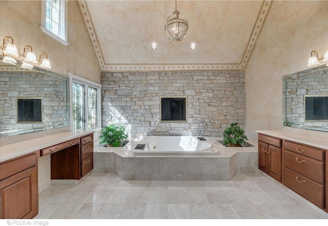 bathroom with a high ceiling, vanity, and a relaxing tiled tub