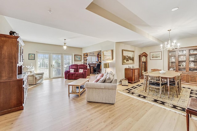 living room with light hardwood / wood-style flooring and a chandelier