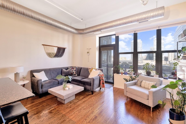 living room with a wealth of natural light and dark wood-type flooring