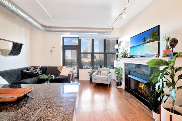 living room with a tile fireplace and hardwood / wood-style floors