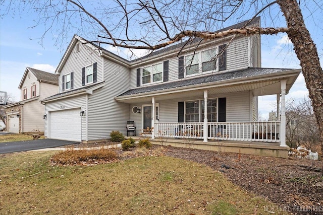 view of front facade featuring a front lawn, covered porch, and a garage