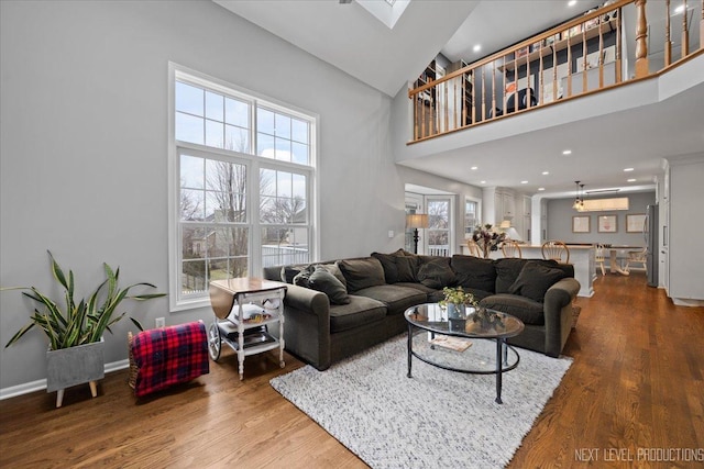 living room featuring ornate columns, hardwood / wood-style floors, and a towering ceiling