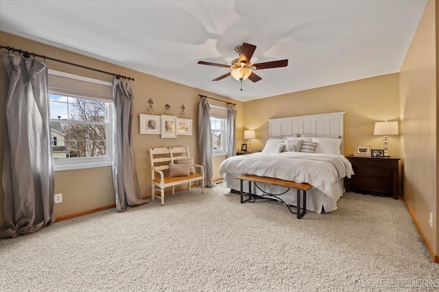 carpeted bedroom featuring multiple windows and ceiling fan