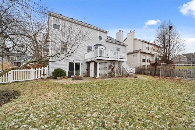 back of property with a yard, an outdoor fire pit, and a wooden deck