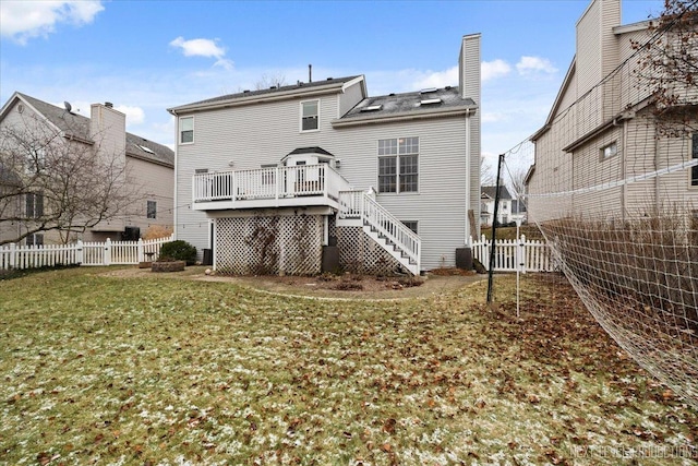 back of property with a yard and a wooden deck