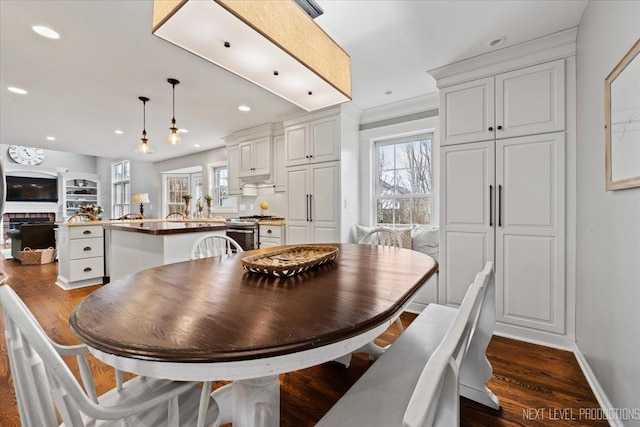 dining area with dark wood-type flooring and ornamental molding