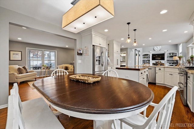 dining space featuring built in shelves and dark hardwood / wood-style flooring