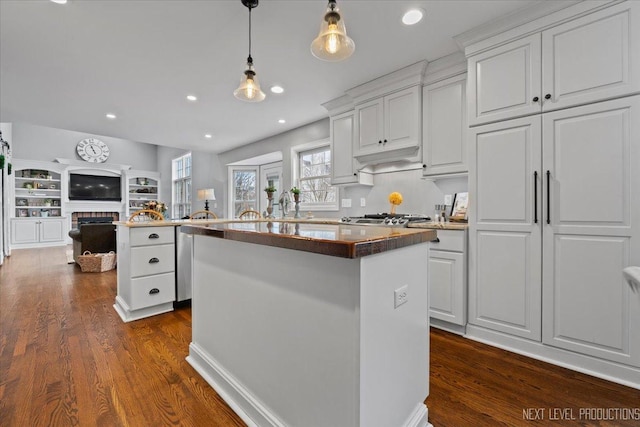 kitchen featuring a center island, white cabinets, sink, dark hardwood / wood-style floors, and decorative light fixtures