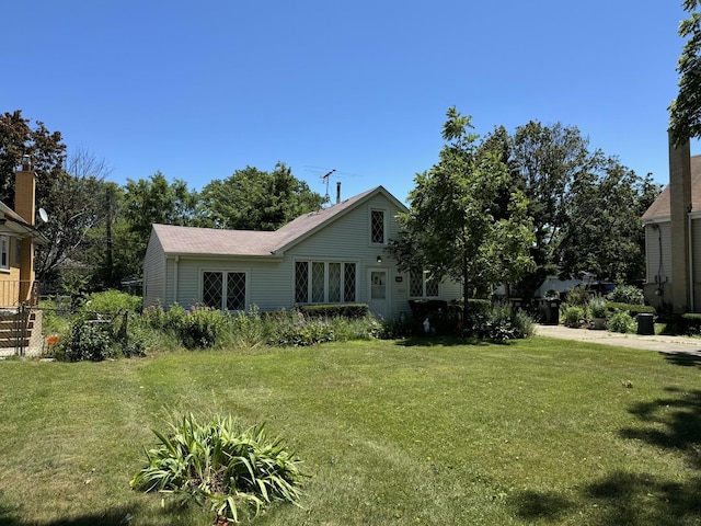 rear view of house featuring a yard