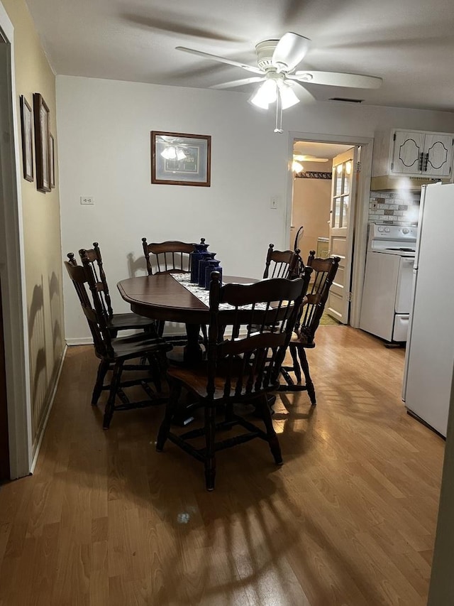 dining room with ceiling fan and light hardwood / wood-style flooring