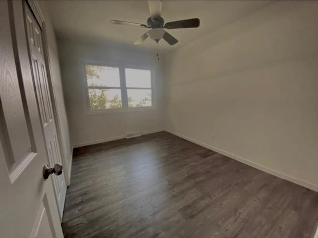 unfurnished bedroom with ceiling fan and dark wood-type flooring