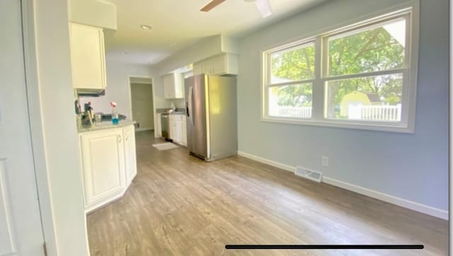 interior space with ceiling fan and light wood-type flooring