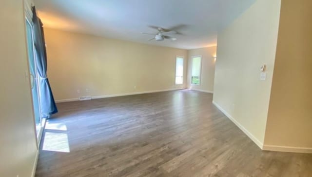 spare room featuring dark hardwood / wood-style flooring and ceiling fan