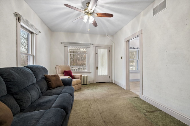 living room with ceiling fan, light colored carpet, and radiator