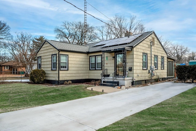 view of front of home featuring a front yard and solar panels