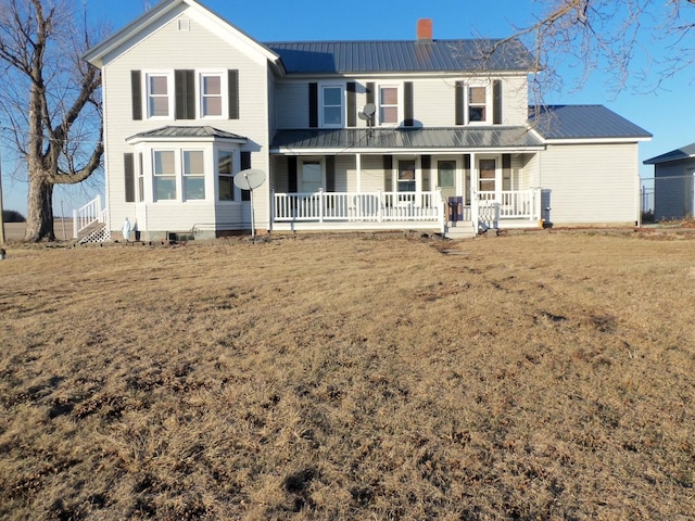 back of property featuring a porch and a yard