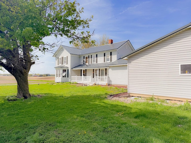 174 Rockyford Rd, Sublette, IL 61367 - back of property with covered porch, a lawn, metal roof, and a chimney
