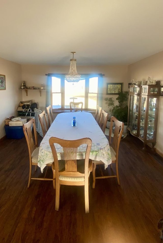 dining space featuring dark hardwood / wood-style floors and an inviting chandelier