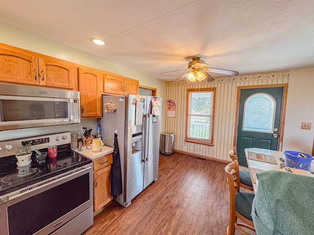 174 Rockyford Rd, Sublette, IL 61367 - kitchen featuring stainless steel appliances, light wood-type flooring, a ceiling fan, baseboards, and a textured ceiling