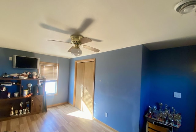 bedroom featuring ceiling fan, a closet, and light wood-type flooring